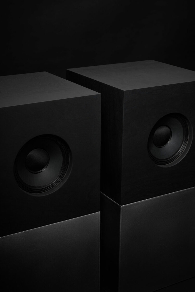 Studio D.A and Nocs debut the Braque stereo system: two black, rectangular speakers with visible circular drivers positioned side by side against a dark background.