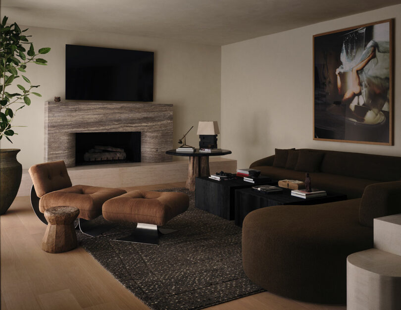 Modern OSKLO-inspired living room with neutral tones, a brown sectional sofa, lounge chairs, dark coffee tables, a textured rug, fireplace, and large wall-mounted TV.