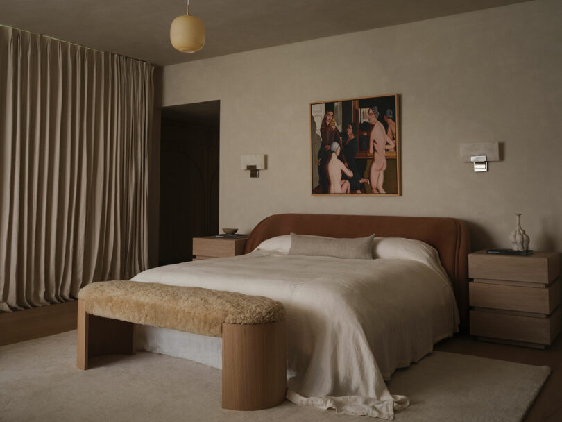 Modern OSKLO bedroom with a curved headboard bed, textured bench, two nightstands, wall sconces, beige curtains, and a framed artwork above the bed.