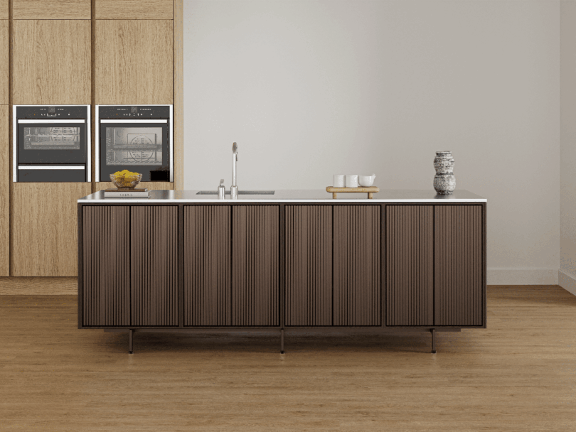 Moderna cocina minimalista con isla panelada en madera Vipp, horno empotrado, fregadero y decoración minimalista sobre suelos de madera clara.
