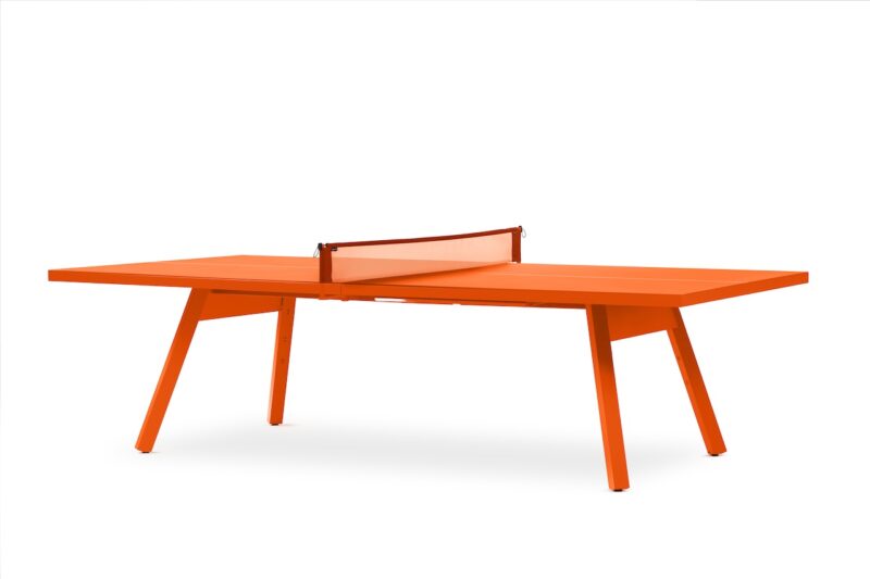 Mesa de ping pong de color naranja brillante con red naranja sobre cuatro patas en ángulo sobre fondo blanco.