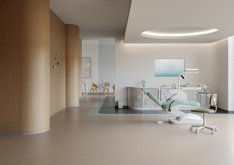 Modern dental clinic interior with a dental chair, equipment, and minimalist decor featuring Tarkett flooring, light wood, neutral tones, and ample natural light.