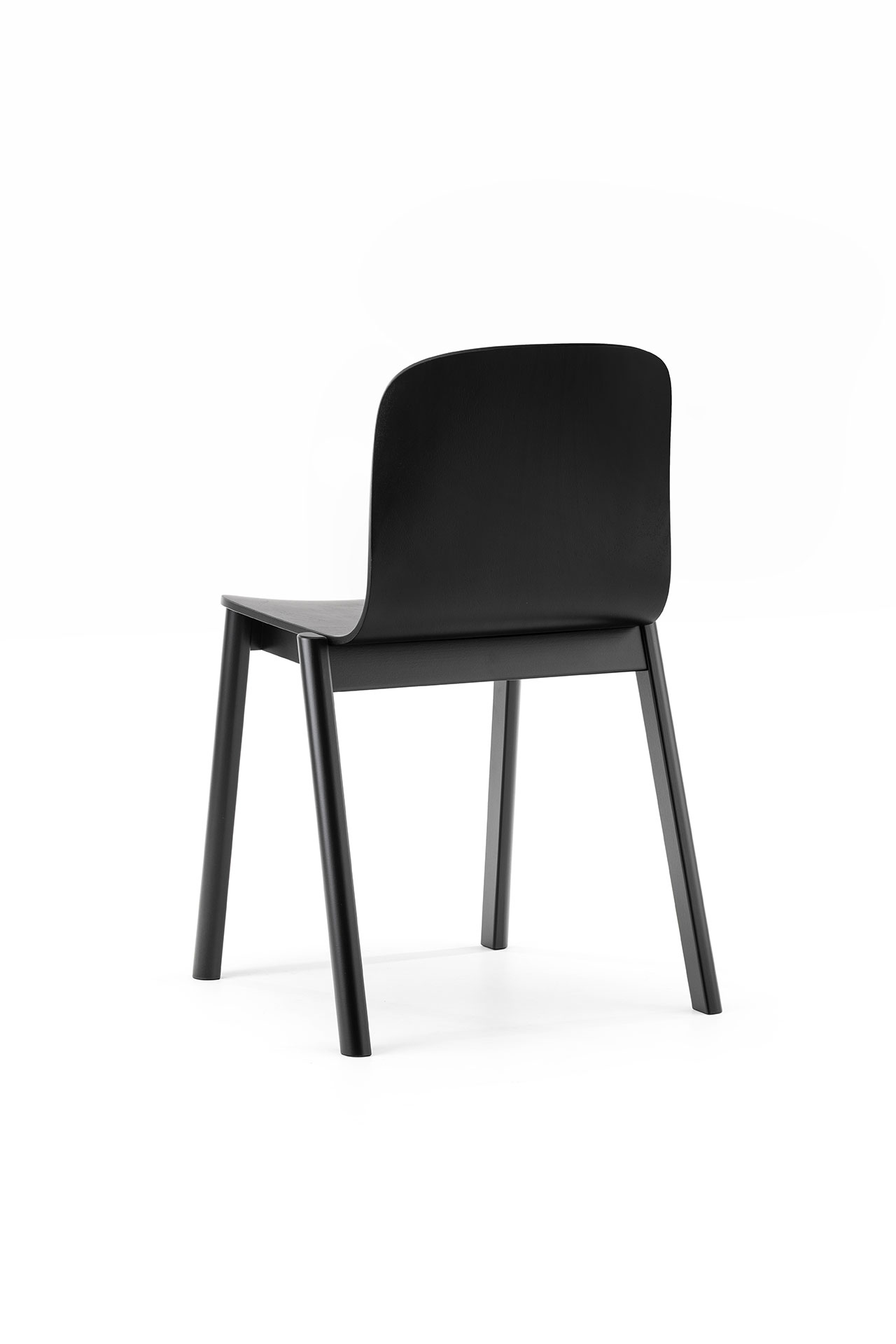 La silla minimalista negra de Alexander Gufler presenta un respaldo curvo y patas rectas, sobre un fondo blanco puro.