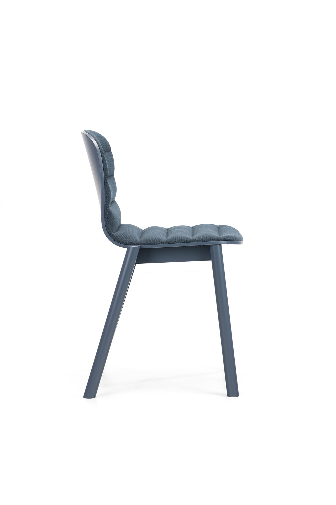 Vista lateral de una moderna silla tapizada en azul de Alexander Gufler, que cuenta con un asiento y respaldo capitoné y cuatro patas inclinadas sobre un fondo blanco.