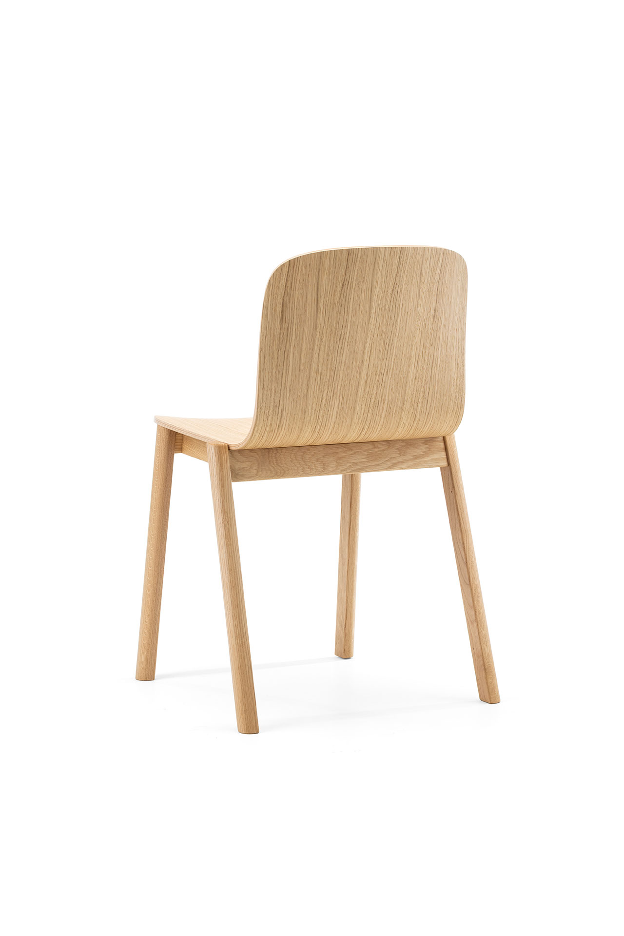 Una sencilla silla de madera, diseñada por Alexander Gufler, con respaldo curvo y cuatro patas rectas, vista desde atrás sobre un fondo blanco.