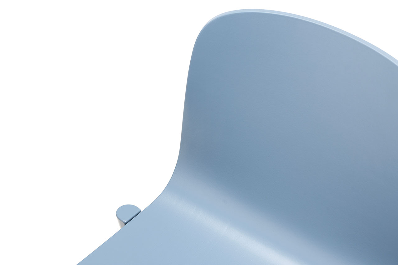 Primer plano minimalista de una silla azul claro con respaldo y asiento curvados inspirados en Alexander Gufler, sobre un fondo blanco.