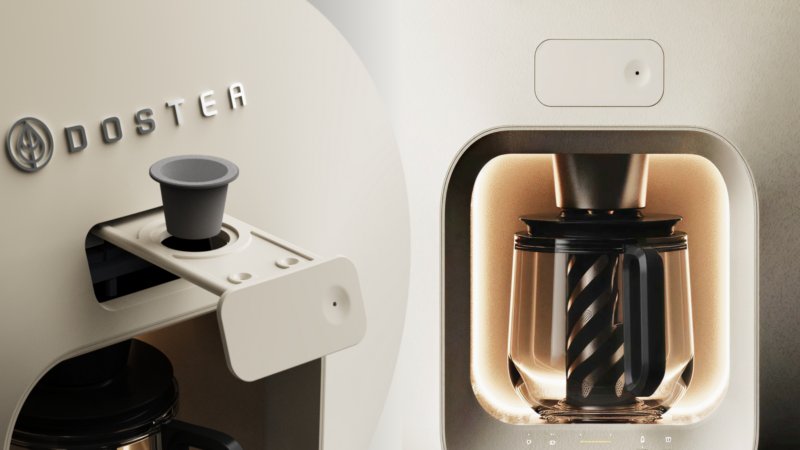 Close-up of a modern DOSTER coffee machine, also compatible as a Dostea chai maker, showing the control button and glass carafe inside a softly lit compartment.