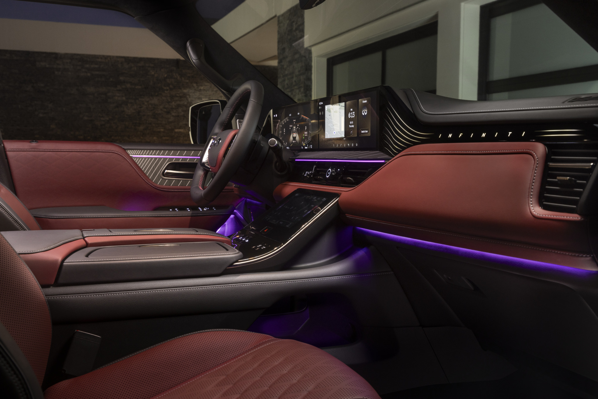 Interior of an Infiniti vehicle with red leather seats, a digital dashboard, and purple ambient lighting.