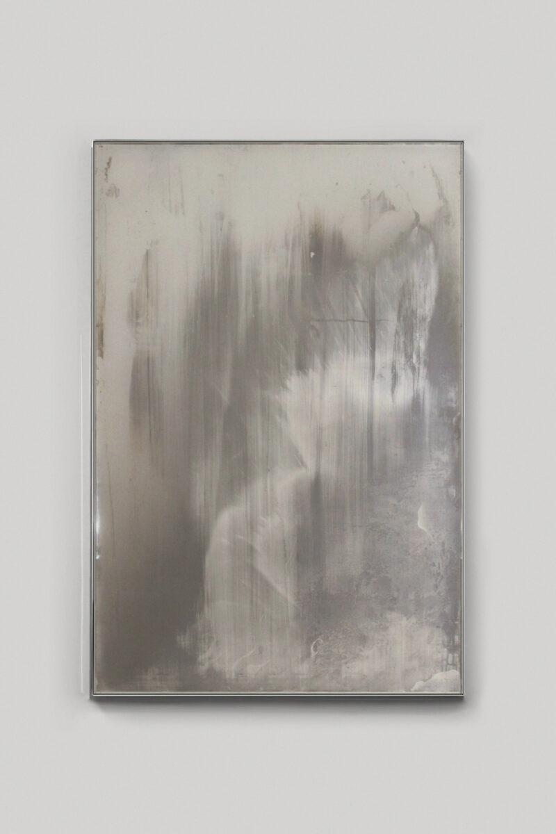 Rectangular mirror with a distressed, cloudy surface in a thin metal frame.